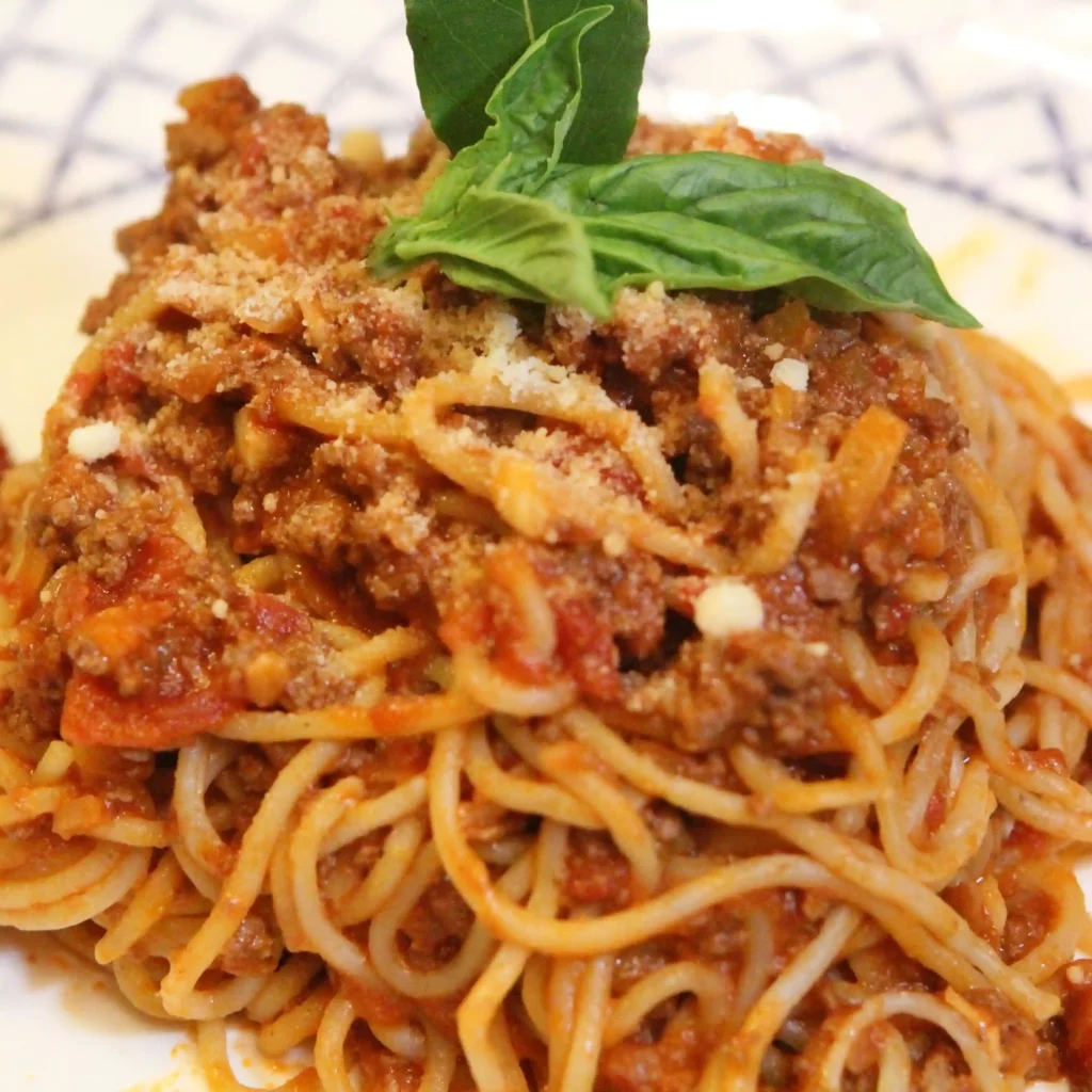 Spaghetti à la Sauce Viande (Pas Bolognaise) : Une Recette Maison Simple et Savoureuse
Vous cherchez une sauce viande maison riche et réconfortante pour vos pâtes, sans complication ni ingrédients difficiles à trouver ? Cette recette facile de spaghetti à la sauce viande est parfaite. Ce n’est pas une bolognaise traditionnelle — pas de lait, pas de vin, ni de mirepoix — mais une sauce tomate généreuse, parfumée aux herbes fraîches et à la viande hachée maigre, mijotée doucement pour révéler toutes ses saveurs.
Que ce soit pour un repas en famille, une préparation à l’avance ou simplement une envie de pâtes, cette sauce tomate viande, mijotée lentement, est un classique fiable. Servez-la avec des spaghettis aux œufs frais et régalez-vous en un peu plus d’une heure.
👉 Regardez la vidéo complète sur YouTubePourquoi Vous Allez Adorer Cette Sauce Viande pour Pâtes
✅ Prête en un peu plus d’une heure
✅ Simple et goûteuse, sans étapes compliquées
✅ Saveurs riches de tomate, herbes et ail
✅ Parfaite avec des spaghettis ou autres pâtes
✅ Convient à toute la famille, et peut se congelerIngrédients
Pour la Sauce
1 kg de boeuf haché extra-maigre1 kg de tomates broyées1 kg de tomates en dés2 oignons moyens, hachés4 gousses d’ail, pelées et écrasées1 c. à soupe de thym séché2 feuilles de laurierQuelques feuilles de basilic frais1 c. à café de cumin moulu½ c. à café de piment de la Jamaïque moulu (allspice)Sel et poivre noir fraîchement moulu, au goûtPour les Pâtes
500 g de spaghettis aux œufs frais1 c. à soupe de sel pour l’eau de cuisson1 à 2 c. à soupe d’huile d’oliveGarniture
Parmesan râpéBasilic fraisFacultatif : feuille de laurier pour la présentationInstructions
1. Faire Dorer la Viande Hachée
Dans une grande casserole ou un faitout, chauffez à feu moyen-élevé. Ajoutez le boeuf haché sans huile et émiettez-le avec une cuillère. Laissez-le dorer tranquillement.
Lorsque la viande commence à rendre son jus et sa graisse, remuez pour bien colorer uniformément.
2. Ajouter les Aromatiques
Ajoutez les oignons hachés et faites-les cuire jusqu’à ce qu’ils soient translucides. Ajoutez ensuite l’ail écrasé, salez, poivrez, et mélangez bien.
L’arôme va se développer à cette étape.
3. Construire la Sauce
Ajoutez les tomates broyées et en dés, puis rincez les boîtes avec un peu d’eau (environ 125 ml) et versez ce liquide dans la casserole — cela aide à déglacer et ajoute du volume.
Ajoutez le thym, les feuilles de laurier, le cumin, le piment de la Jamaïque et le basilic frais déchiré à la main. Remuez bien et portez à légère ébullition.
💡 Pour une saveur plus profonde, vous pouvez déglacer avec un peu de vin blanc ou bouillon de poulet après la cuisson de la viande.
4. Laisser Mijoter
Réduisez le feu et laissez mijoter doucement à découvert pendant 1 heure en remuant de temps en temps. La sauce va s’épaissir et concentrer toutes ses saveurs.
5. Cuire les Pâtes
Pendant que la sauce termine, portez à ébullition une grande casserole d’eau salée. Faites cuire les spaghettis jusqu’à ce qu’ils soient juste tendres — environ 2 minutes après le retour de l’ébullition si ce sont des pâtes fraîches.
Égouttez-les et mélangez-les à l’huile d’olive. Ne les rincez pas, l’amidon aide la sauce à adhérer.
6. Dresser et Servir
Mélangez les pâtes chaudes avec quelques cuillères de sauce et du parmesan râpé. Mélangez bien.
Servez avec un peu plus de sauce, une feuille de basilic fraîche, et si vous voulez, une feuille de laurier pour la présentation.Substitutions et Variantes
Boeuf haché → Vous pouvez utiliser un mélange de boeuf et porc haché, ou même de la saucisse italienne douce pour plus de richesse et de goût.
Cette option est parfaite si vous aimez notre recette de Pâtes alla Zozzona au goût prononcé.Piment de la Jamaïque → Remplacez par une pincée de muscade ou omettez si vous préférez un goût plus neutre.Basilic frais → 1 c. à café de basilic séché fait aussi très bien l’affaire.Tomates → Utilisez de la purée de tomates ou du passata si vous n’avez pas de tomates broyées.Conseils pour une Sauce Viande Parfaite
Mijoter à feu doux et longuement — au moins 1 heure, c’est la clé pour des saveurs intenses.Ne pas rincer les pâtes — l’amidon permet à la sauce d’adhérer.Ajouter une pincée de sucre — pour équilibrer l’acidité des tomates.Cuire lentement les oignons — ils libèrent un sucre naturel et enrichissent la sauce.Questions Fréquentes
Est-ce que cette sauce est une bolognaise ?
Non. La bolognaise traditionnelle contient du lait, du vin blanc et un mélange de légumes appelé mirepoix. Ici, c’est une version plus simple, avec une saveur plus concentrée de tomate.
Puis-je congeler cette sauce ?
Oui, parfaitement. Laissez-la refroidir, portionnez, puis congelez jusqu’à 3 mois.
Quelles pâtes conviennent le mieux ?
Les spaghettis sont classiques, mais cette sauce s’adapte aussi très bien aux rigatoni, penne, fusilli, ou même des pâtes farcies comme les coquilles farcies ricotta-épinards.
Avec quoi puis-je accompagner ce plat ?
Cette sauce s’accorde parfaitement avec des toasts au beurre à l’ail maison ou des pommes parisiennes.Plus de Recettes à Découvrir
Si cette recette vous plaît, découvrez aussi :
🍝 Le Grand Guide des Recettes de Pâtes Maison🍅 Sauce Tomate Maison aux Tomates Fraîches🧀 Pâtes Crémeuses Mozzarella Parmesan🧁 Desserts au Chocolat Faciles et Gourmands🥞 Recettes Faciles de Brunch Maison🍨 Glace au Chocolat Noir Sans Sorbetière