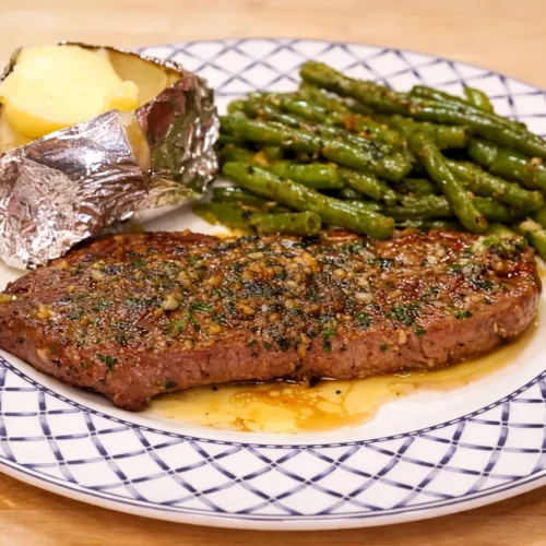 Steak pas cher, pomme de terre au four et beurre &agrave; l&rsquo;ail